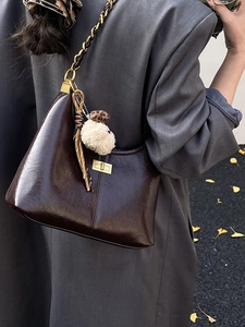 Deep brown glossy leather half-moon chain bag with gold metal buckle and plush charm