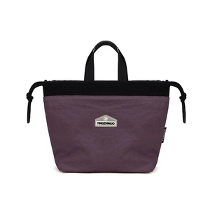 Detail of purple nylon handbag featuring a brand logo patch and black drawstring cords