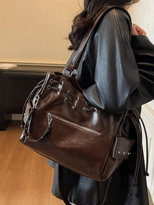Grand sac cabas vintage marron foncé en similicuir brillant porté par un mannequin