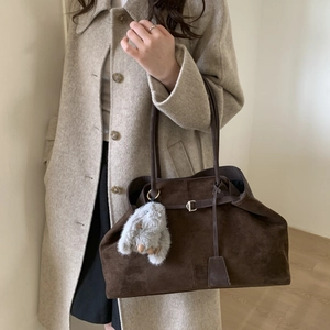 Detail of dark brown frosted suede tote bag featuring a leather strap and bunny charm