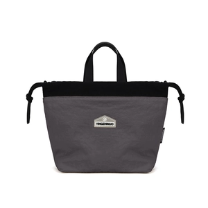 Detail of grey and black nylon bucket bag featuring drawstring closure and top handles