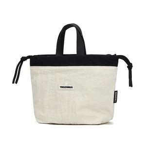 Close-up of the black and white nylon crossbody bag featuring the shield brand logo