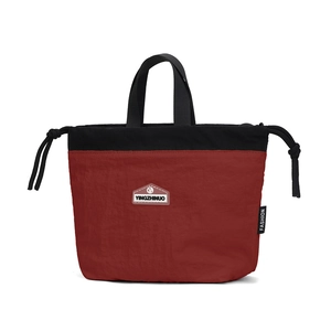 Close-up of contrast nylon drawstring bag with branded patch and woven ribbon handle