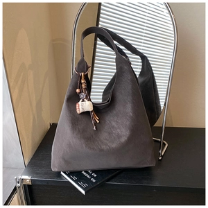 Close-up of deep brown suede hobo bag with a creative coffee themed charm and bead detail