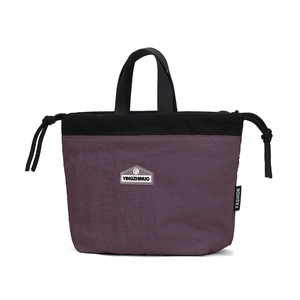 Detailed close-up of nylon drawstring bag with brand logo and fashion tag