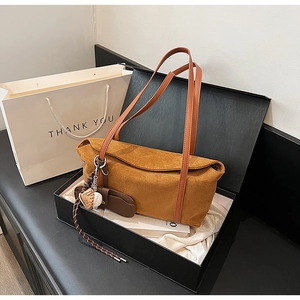Brown suede shoulder bag with baseball charm in a branded gift box and bag set