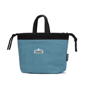 Detail of the blue and black nylon drawstring bag with brand label and woven handle
