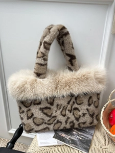 Faux fur leopard print tote bag with cream trim displayed on a wicker chair