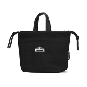 Detailed shot of a black nylon drawstring handbag with a branded badge and side label