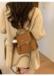 Nahaufnahme des braunen Vintage-Lederrucksacks am Model im beigen Wollmantel