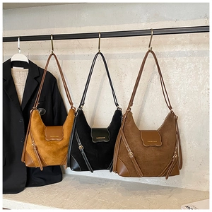 Sacs Hobo en daim moutarde, noir et marron avec bordures en cuir et longs pompons