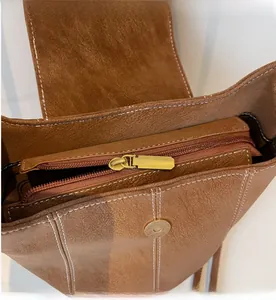 Détail de l'intérieur du sac en cuir marron, poche zippée fluide et fermoir magnétique