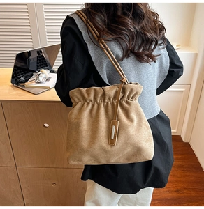 French retro suede bucket bag with soft pleated design shown in a lifestyle street setting