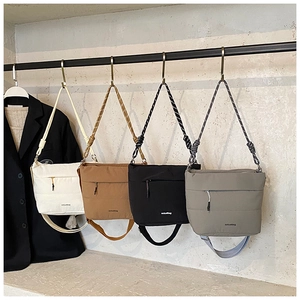 Quilted nylon bucket bags in white, khaki, black, and gray on display for AW 2025 fashion