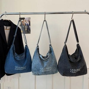 Multiple colors of large denim hobo bags hanging on a display for daily styling