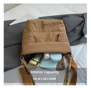 Spacious interior of khaki quilted tote bag showing phone, notebook and daily items