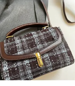 Close-up of retro brown wool fabric handbag with premium leather trim and golden clasp