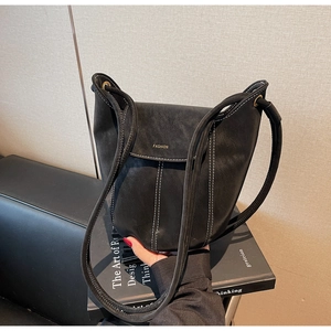 Détail du sac seau noir avec surpiqûres blanches contrastées et logo Fashion gravé