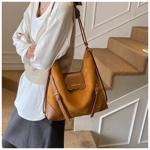 Détail du sac cabas en daim marron avec garniture en cuir et lanières à boucles