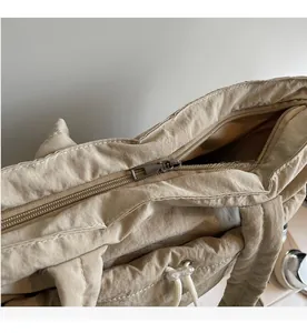 Detailed macro view of the smooth metal zipper and stitching on the quilted tote bag