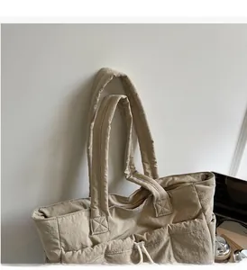 Close-up of beige nylon tote bag with reinforced wide handles and durable stitching