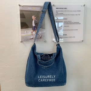 Detail of blue denim hobo bag featuring leisure art print on high-quality fabric