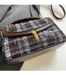 Detail of vintage brown tweed and leather handbag with a gold hardware lock buckle