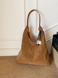 Brown faux suede hobo tote bag with a coffee cup charm on a minimalist background