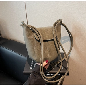 Détail du sac seau vert olive avec surpiqûres contrastées blanches et logo doré