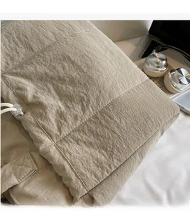 Macro detail of khaki quilted tote bag fabric with soft texture and white stitching