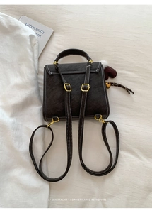 Detail eines dunkelbraunen Lederrucksacks mit Kontrastnähten und goldener Hardware