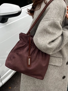 Fashionable dark brown suede bucket bag for women with drawstring and metal detail