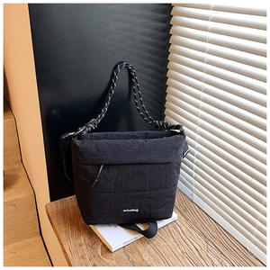Detail of black nylon crossbody bag with woven strap and aotuatbag logo in a minimalist scene