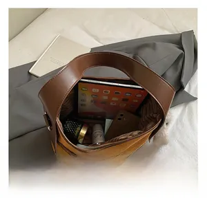 Spacious interior of caramel leather bucket bag holding tablet and beauty essentials