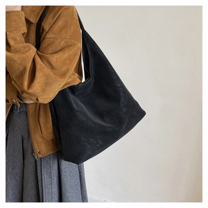 Macro detail of black hobo bag in matte suede leather showing textured material and large capacity