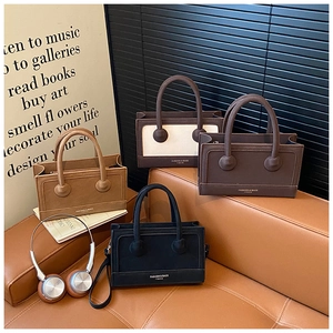 Detailed view of vintage tote bags in black, brown, and coffee on a leather sofa