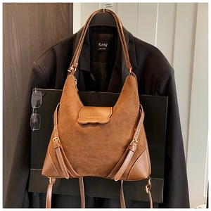 Détail du sac à bandoulière vintage en daim marron avec texte mode et sangle décorative