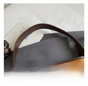 Macro detail of caramel bucket bag showing wrinkled texture and contrast leather handles