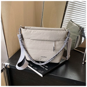 Close-up of light grey nylon bucket bag with chunky rope weave detail and wide strap