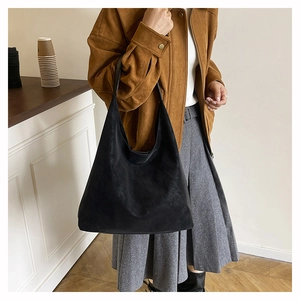 Side view of black suede tote bag shown on model for daily commuting and fashion lifestyle