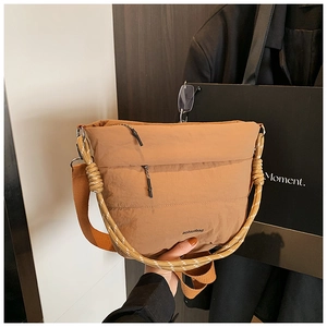 Detailed shot of khaki quilted nylon bucket bag with dual textured shoulder straps