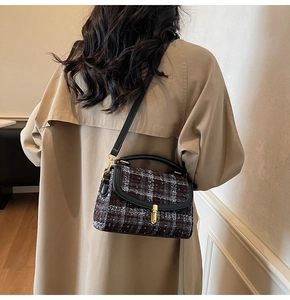 Classic houndstooth crossbody bag with gold twist lock shown on a model in a trench coat
