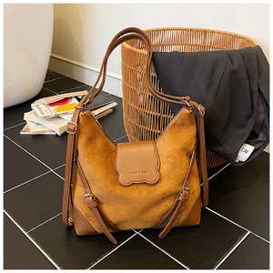 Détail du sac cabas en daim marron avec boucle en cuir et bandoulière réglable