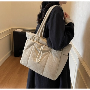 Quilted padded tote bag with drawstring pocket shown on model for size and style