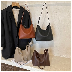 Detailed macro view showing four colors of textured leather hobo bags in office style