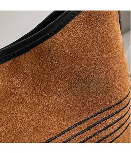 Close-up of brown suede tote bag featuring black edge paint and decorative stitching