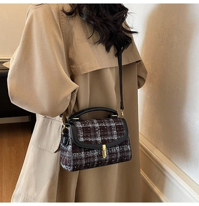 Detail of vintage tweed crossbody bag with gold twist lock on a khaki trench coat