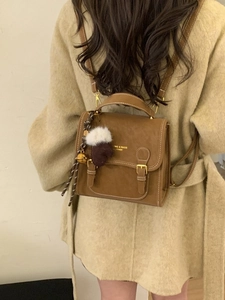 Vintage brauner Damen Rucksack aus Leder mit Kontrastnähten und dekorativem Anhänger