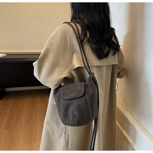Détail du sac seau en cuir anthracite avec surpiqûres contrastées et lettrage doré