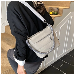 Detail of minimalist beige crossbody bag with woven rope handle and woven strap